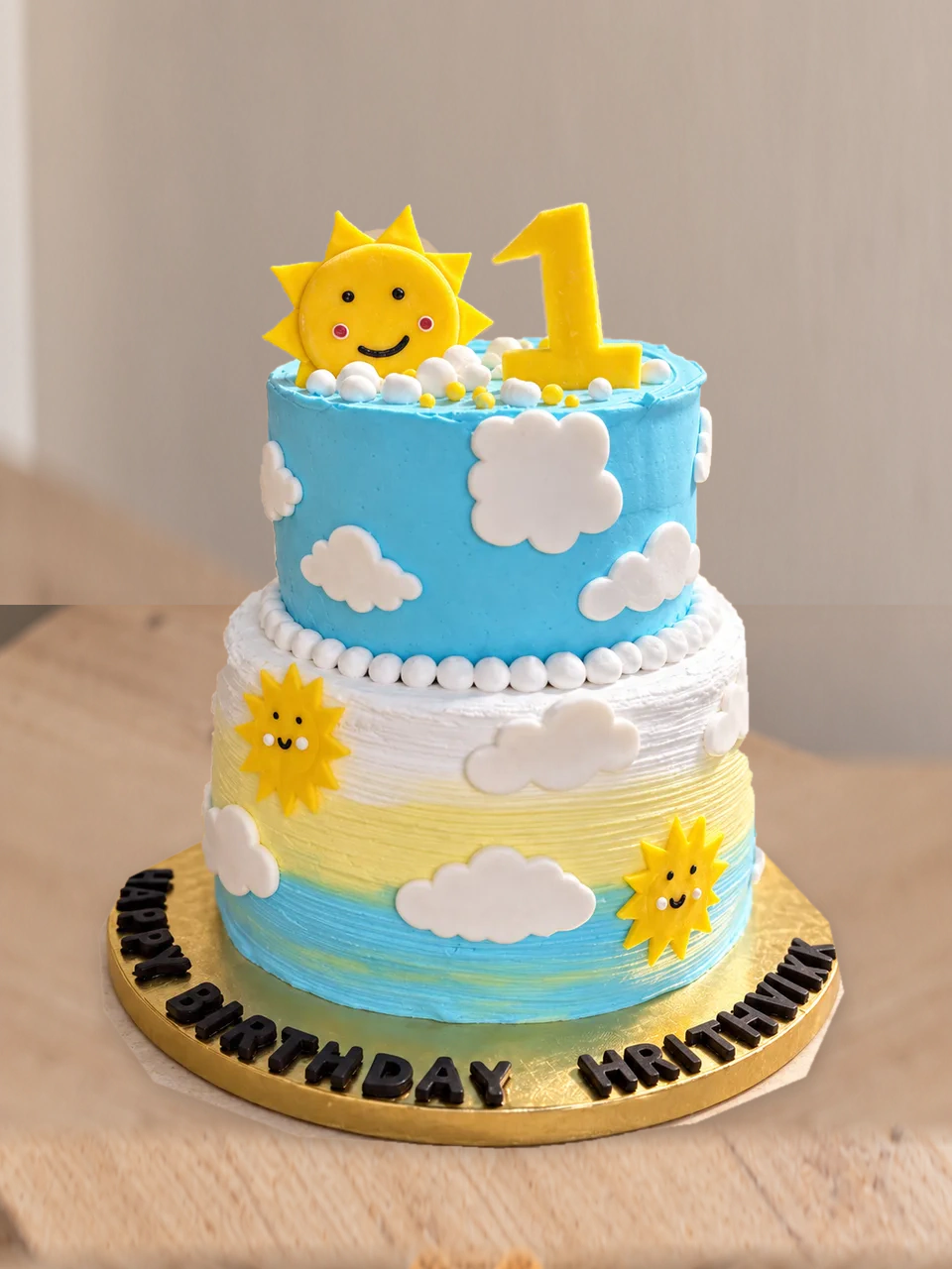 Two-tier sun and cloud cake made for a first birthday